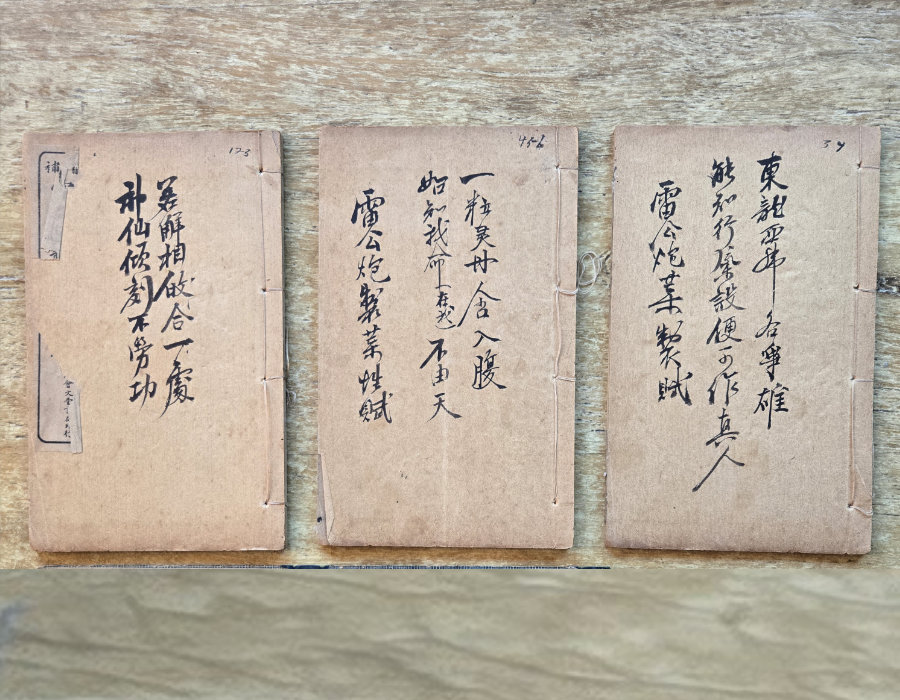 Three antique string-bound medical booklets with handwritten calligraphy